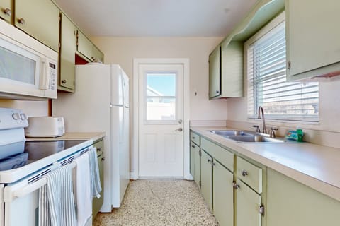 This bright, functional kitchen is perfect for your beach stay, featuring coastal-style cabinetry and all the essentials for easy meals. Ideal for fueling up before the beach or winding down after a sunny day.