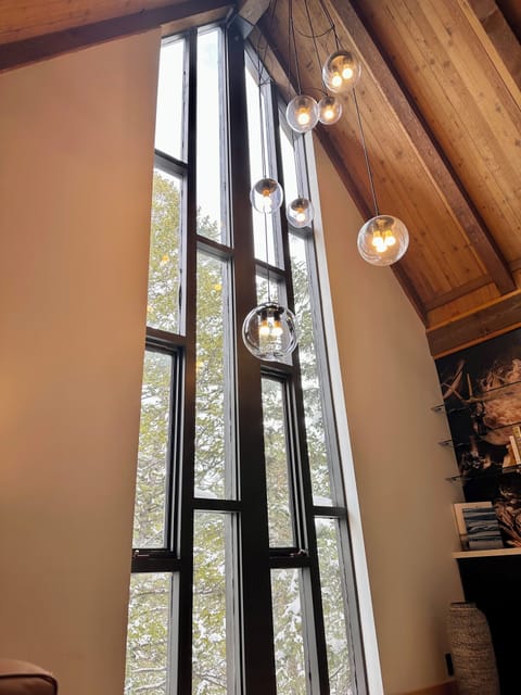 Cozy family room with fireplace, smart TV, cathedral ceiling, hardwood floors.