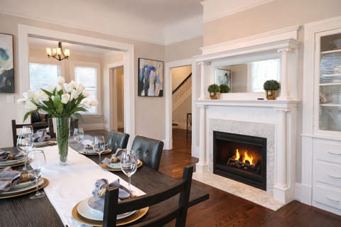 Enjoy a sophisticated dining experience in our beautifully appointed formal dining room. Featuring a grand marble fireplace and a statement table set for six, this space is perfect for celebratory dinners or intimate family gatherings.