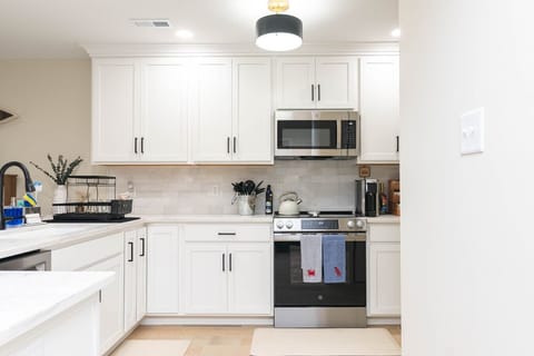 Chef-style kitchen with white cabinetry and breakfast bar.