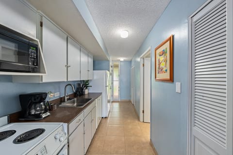 Fully equipped kitchen with white appliances and cabinetry