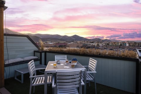 Rooftop terrace with outdoor dining table and mountain views.