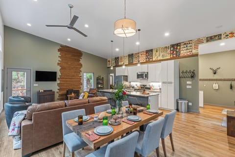 Dining area with a large wooden table and blue upholstered chairs, open to the living room.