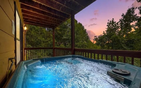 Unwind in your private hot tub as twilight paints the sky in stunning colors above the lush forest canopy.
