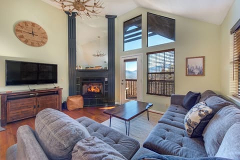 Cozy up in your spacious living room with soaring ceilings, crackling fireplace, and mountain views through expansive windows.