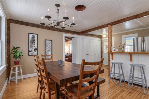 Gather around the handcrafted kitchen table in this charming space featuring rustic wood beams, vintage chandelier lighting, and an open connection to your kitchen island area.