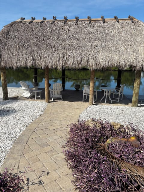 Tiki hut hanging over the water, offering shade, relaxation and tropical vibes.