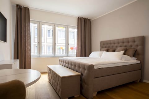 Schlafzimmer mit modernem Boxspring-Bett (180x200) mit durchgehenden Komfort-Topper. Die darunterliegenden Matratzen sind zweigeteilt für einen 2-Personen-Schlafkomfort.