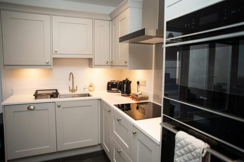 Kitchen with oven, microwave, hob, sink, kettle and toaster