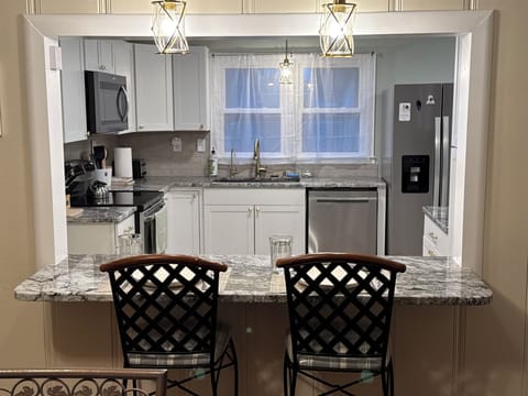 Open floor layout from dining room to kitchen with bar stools