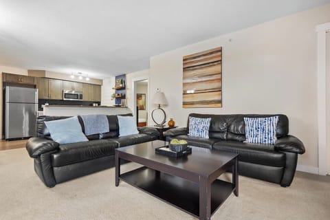 Living room with an electric fireplace, cozy seating options, a Smart TV and walkout access to the private, top-floor balcony.