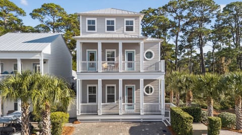Beautiful multi-level beach retreat featuring classic Southern porches and peaceful palm-lined surroundings.