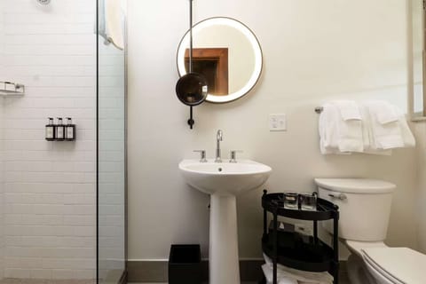 Bright bathroom with walk-in shower and round mirror lighting