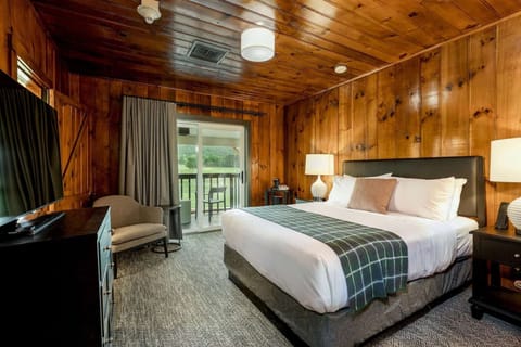 Rustic king room with wood walls and balcony with scenic view