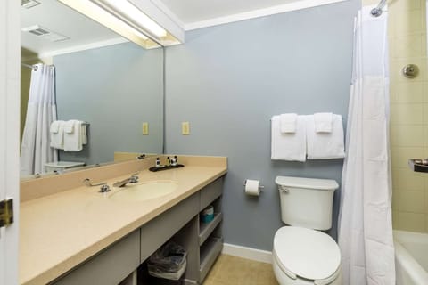 Bathroom with large mirror, open vanity, and shower-tub combo