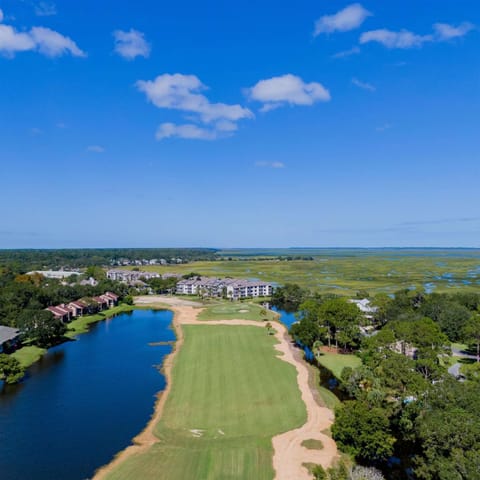 Aerial view of golf course fairway beside lakes and marshland