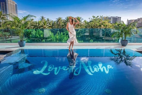 Guest standing above the pool with “Love Aloha” on the floor