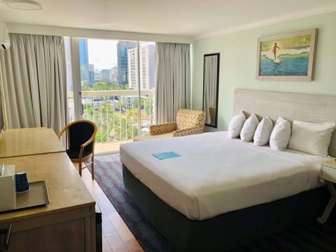 King room with soft light and a wide window looking at the city