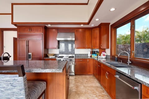 Fully equipped kitchen includes double ovens, full-size fridge, and expansive counter space.