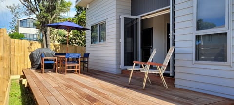 Huge kwila deck with BBQ, table, chairs and umbrella