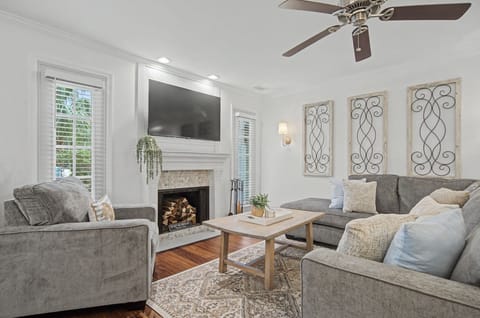 Unwind in this elegant living room with plush gray sofas and modern TV for your perfect evening relaxation.