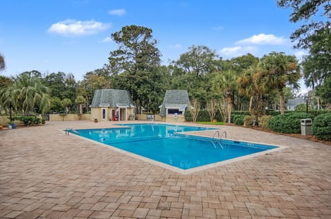 Dive into crystal-clear waters surrounded by lush tropical palms and peaceful landscaping in this inviting community pool area.