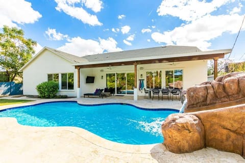 Beautiful resort like backyard with heated pool and waterslide. Misted and shaded rear dining patio with outdoor living room and flatscreen TV. Also an outdoor kitchen with gas grill.