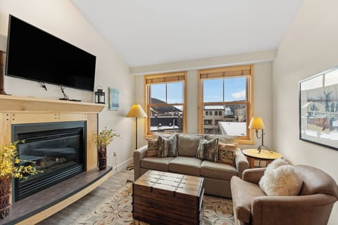 Cozy up by your private fireplace in this bright living room, complete with plush seating and mountain town views.