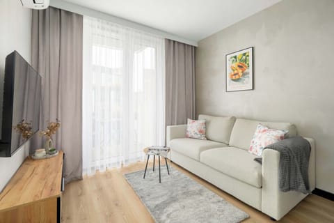 Bright living room featuring elegant décor, soft neutral tones and a cozy sofa.