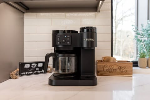 Dedicated coffee station with a Keurig machine, mugs, and supplies for your morning convenience.
