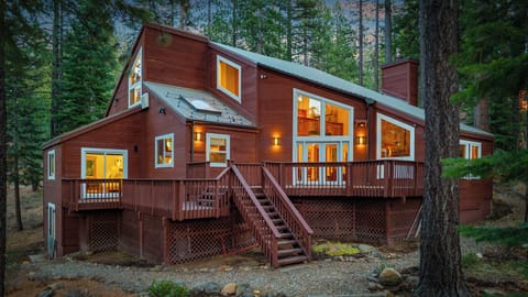 Warm cabin light meets towering pines—your perfect Tahoe retreat awaits.