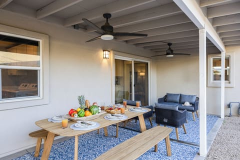 Covered back patio/deck with a large outdoor dining table and seating area.