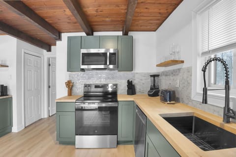 Another view of the modern kitchen highlights new appliances, butcher block counters, and clean finishes throughout. With plenty of space to prep, cook, and gather, it’s designed for effortless meals and relaxed time together.