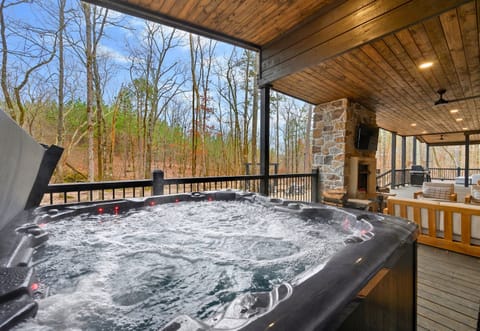 The covered hot tub sits right off the back deck, offering a relaxing spot to soak while taking in peaceful wooded views.c