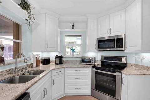 Cook and dine with ease in this spacious kitchen, featuring ample storage, a sleek granite countertop, and a full fridge—perfect for both short getaways and extended stays.