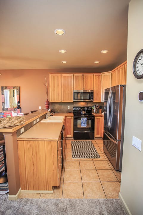 Bright, fully equipped kitchen with granite counters and stainless steel appliances.