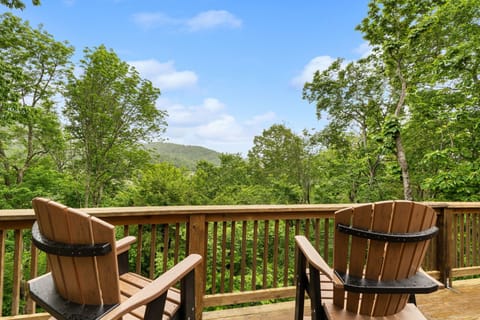 Private deck with Adirondack chairs and serene mountain-view treetops