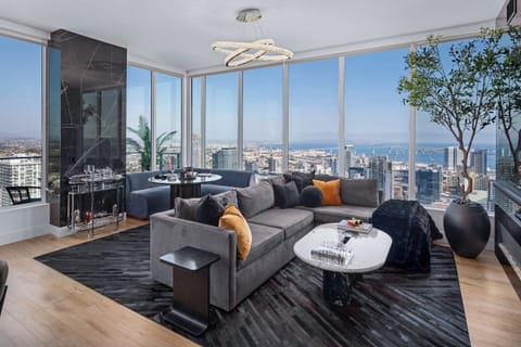 Another view of the modern living room with a dark sectional and a round coffee table.