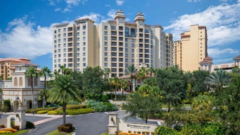 Grand resort entrance surrounded by palm trees and gardens