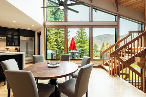 Open dining area with vaulted ceilings and large windows.