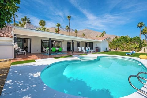 Sparkling pool, shaded patio dining, lounge chairs, and mountain backdrop — the heart of the property and exactly what the photos promise
