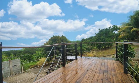 Elevated deck with lush tropical views and blue-sky serenity.