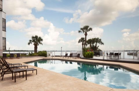 Dive into sunlit pool serenity with sparkling waterfront views.