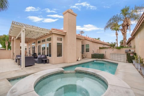 Private backyard pool w/ lounge seating and tall palms creating a relaxed desert escape.