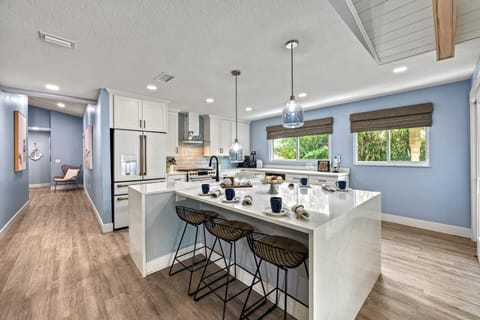 The airy kitchen showcases sleek coastal finishes and plenty of space for family meals and casual dining.