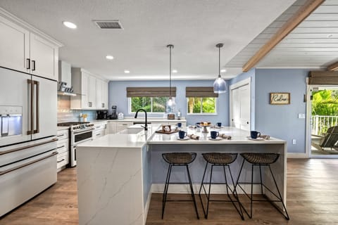 The spacious kitchen island with breakfast bar invites everyone to gather, cook together, or sip morning coffee in style.