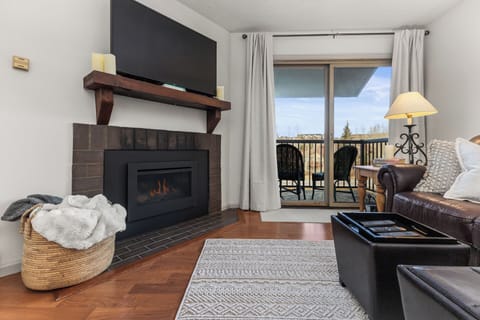 Gas Fireplace with Dark Brick Hearth, Distressed Wood Mantel, and Large HDTV