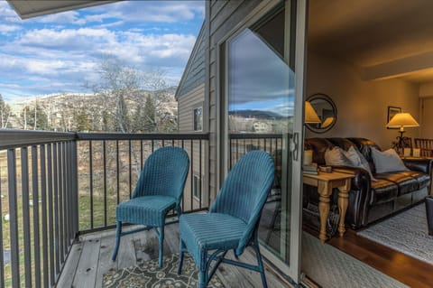 Outdoor Seating on Covered Balcony with Two Teal Whicker Chairs