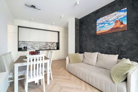 Bright living room with a comfortable sofa, dining area, and large windows providing plenty of natural light.