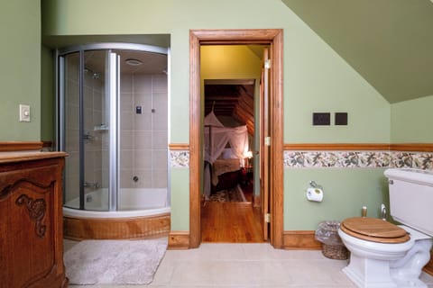 Private bathroom featuring a curved glass–enclosed steam shower, offering a true spa experience within the suite.